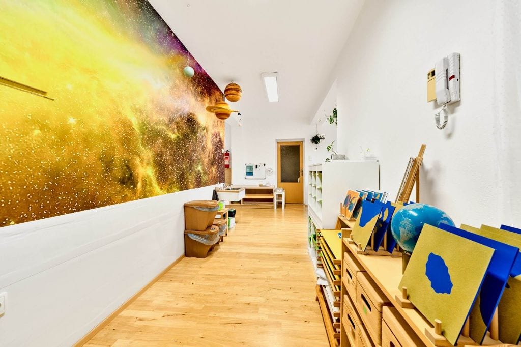 Pohled do chodby, kde jsou pomůcky k oblasti naše země v Montessori dětské skupině Dobromysl
